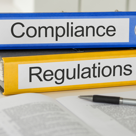 Photo of two notebook binders with the words Compliance and Regulations